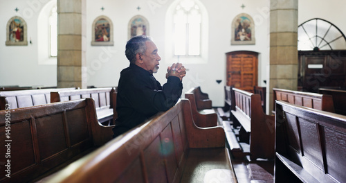 Church, senior man and prayer for faith with religion, respect or worship God at funeral service. Christian, chapel and person praying for hope, holy spirit or widower ask for forgiveness at memorial