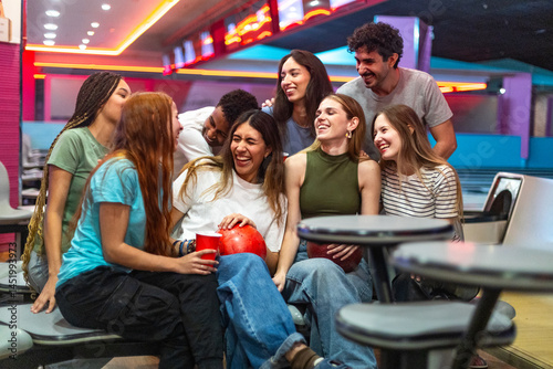 Group of friends laughing together while bowling