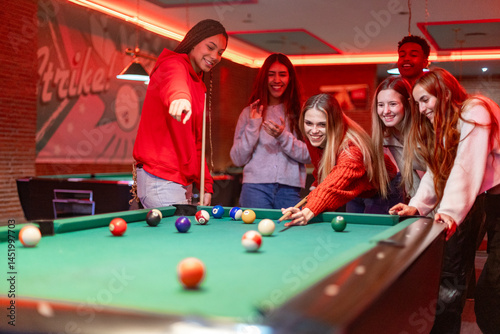 Canvas Print Friends playing billiards and having fun together in pub