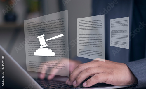 Legal documents and hammer. Lawyer is reviewing and preparing legal documents for court case. Hands are typing on laptop computer keyboard at desk.
