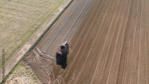 Tractor cultivating dry farmland in sunlight