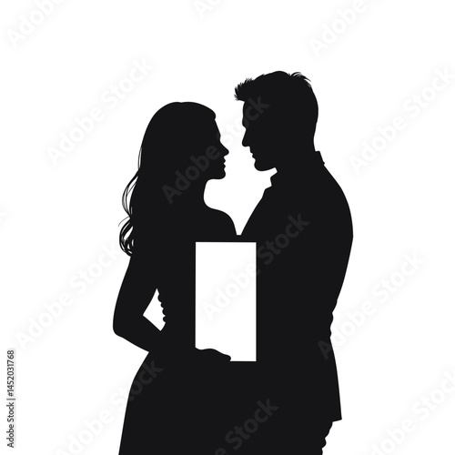 Couple holding a photo frame while gazing lovingly at each other  