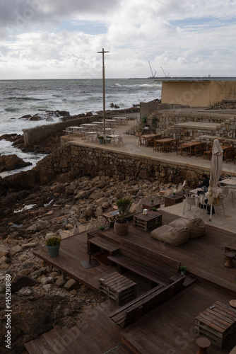 a cafe with a wooden pier on the ocean front in Porto, Portugal