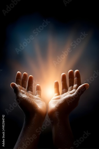 Hands reaching for a glowing light in darkness