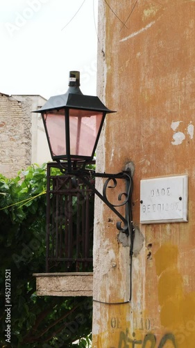Vintage lantern on an old wall in the historic Plaka district of Athens, Greece. A charming street scene with classic architecture and a nostalgic Mediterranean vibe