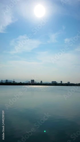 A peaceful panoramic view of Da Nang, Vietnam, captured from across the Han River. The image showcases the city’s skyline and serene water reflections, with the modern Tran Thi Ly Bridge adding a stri