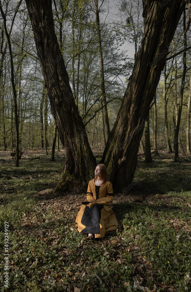 young woman in medieval dress in spring forest