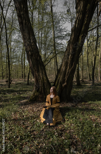 Obraz na płótnie young woman in medieval dress in spring forest w salonie