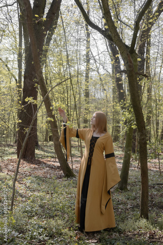 young woman in medieval dress in spring forest