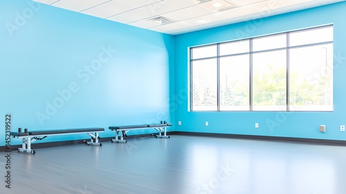 Empty Fitness Studio with Blue Walls, Bright, modern fitness studio with large window.