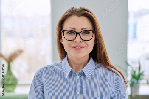 Obraz na płótnie Headshot portrait of smiling businesswoman with glasses in blue shirt w salonie