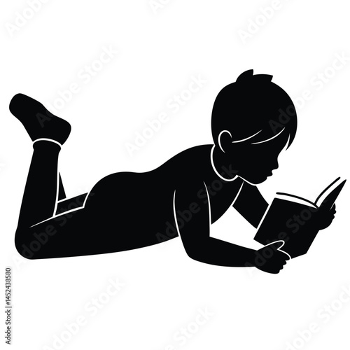 Child engrossed in reading a book, lying down