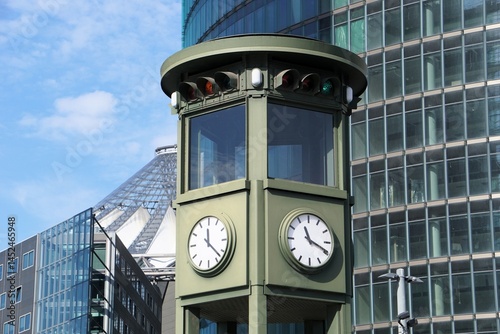 Foto The historic first traffic light on Potsdamer Platz, Berlin, Germany, with a skyscraper and the iconic roof of the Center Potsdamer Platz in the background