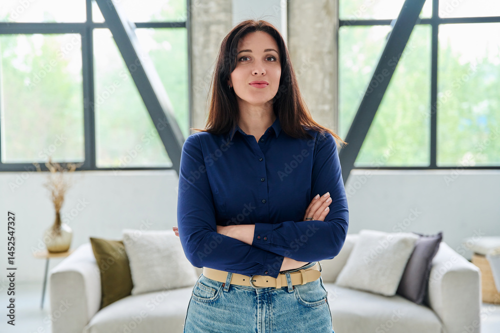 Portrait of beautiful young confident woman in office with couch