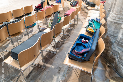 Obraz na płótnie Opened musical string instrument cases seen on chairs within a famous English cathedral during a live practice session. The seating is for members of the public during the performance. w salonie