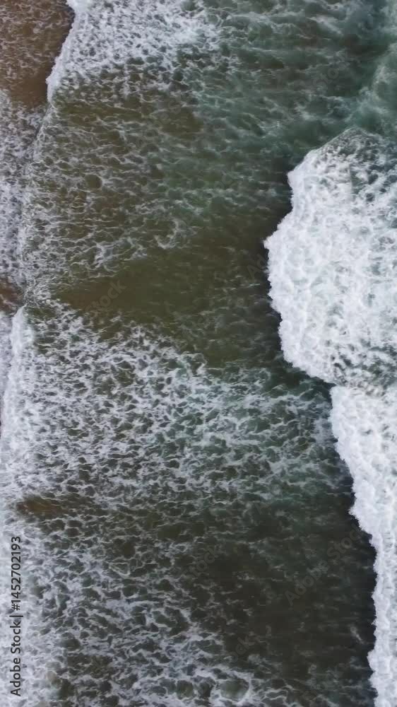 Aerial vertical slow-motion of foamy waves wetting the sand in Carrapateira, Portugal Aerial vertical slow-motion of foamy waves wetting the sand in Carrapateira, Portugal