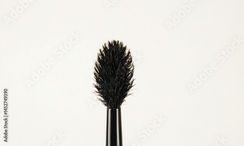 A close-up shot of a mascara brush on a white background, ideal for beauty and cosmetics related uses