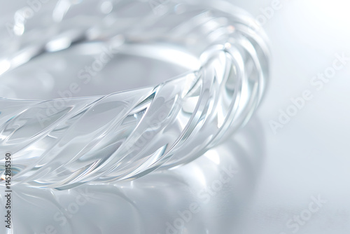 Close-Up of Transparent Glass Bracelet with Twisted Design and Soft Light Reflections

