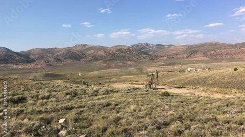 Natural gas well derrick pumping gas in the middle of nowhere Utah.  Gas well extracting natural gas from a small well in the mountains of Utah.
