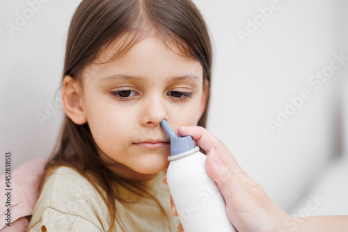 child is sick in bed. Mom gives medicine to her daughter. Mom drips her daughter's nose. Concept disease, pharmaceutics.