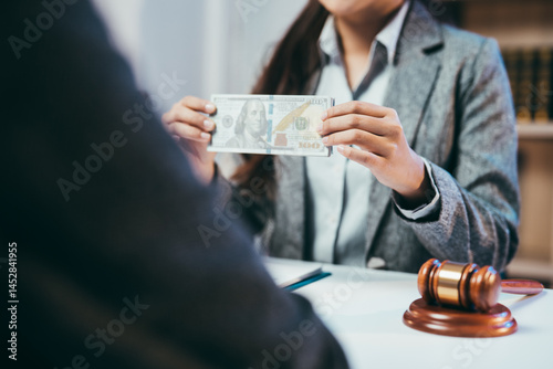 Canvastavla Lawyer showing dollar banknotes to client during a meeting in office, with a gav