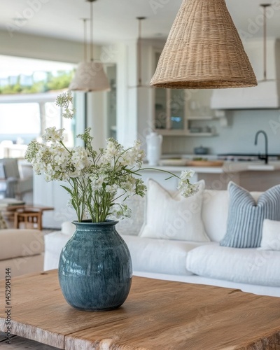 Serene interior with white flowers in a blue vase on a wooden table in a bright coastal home decor showcasing natural light and elegant design