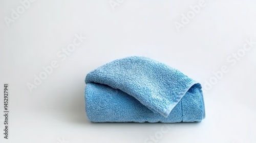 Close-up of light-blue towel with soft nap and curled edges on white background.