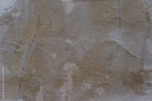 A grey wall with a white mesh pattern. The mesh is in the shape of squares.