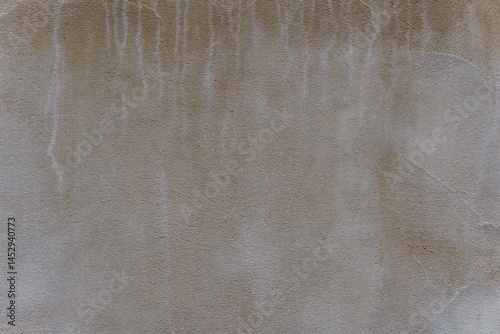 Gray wall with white streaks. The wall is made of concrete.