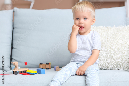 Crying baby boy with toys o...