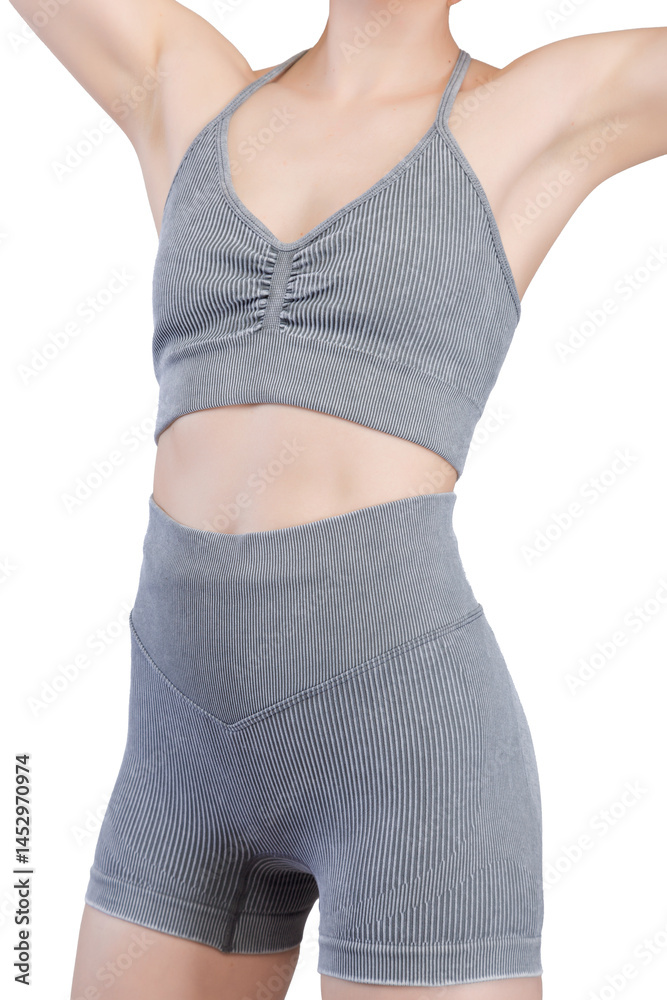 Close-up shot of a woman's lower torso and buttocks wearing grey ribbed knit sports shorts and a matching sports bra.