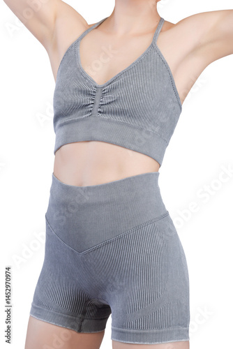 Obraz na płótnie Close-up shot of a woman's lower torso and buttocks wearing grey ribbed knit sports shorts and a matching sports bra. w salonie