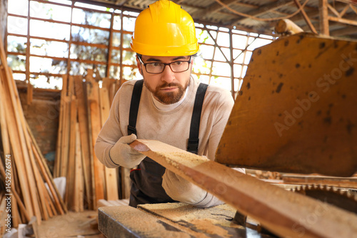 Male carpenter sawing woode...