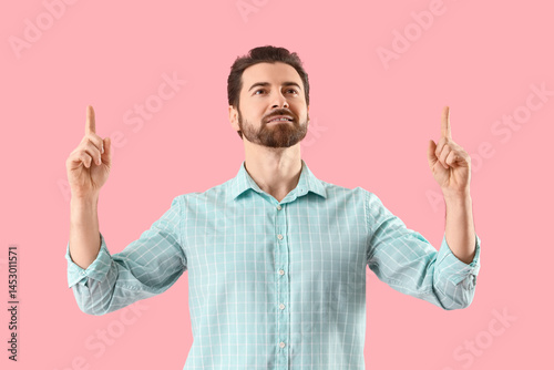 Handsome man pointing at so...