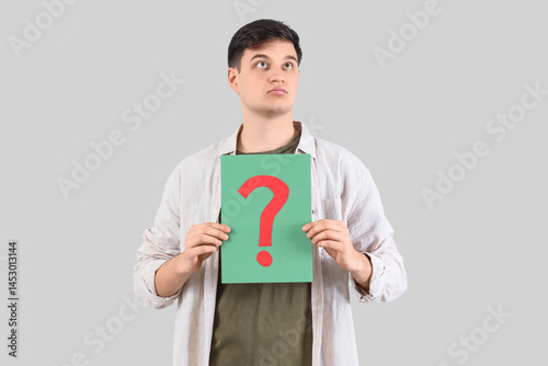 Young man with paper questi...
