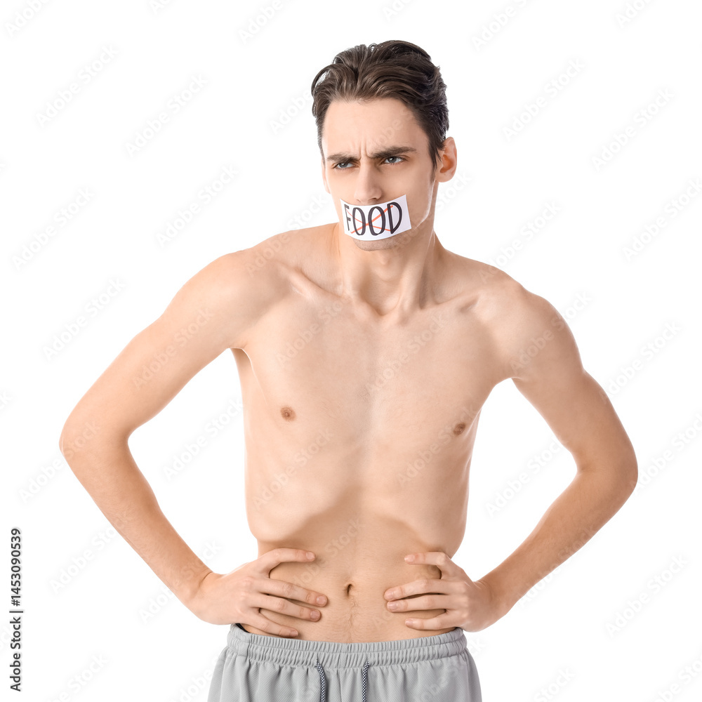 Young man with crossed out word FOOD on taped mouth against white background. Anorexia concept Young man with crossed out word FOOD on taped mouth against white background. Anorexia concept