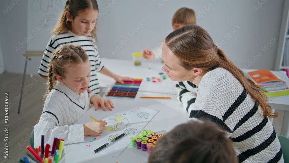 Pupil teacher creating artwork in art school closeup. Lady teaching children