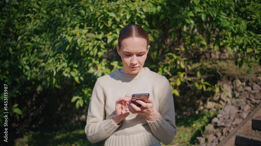 Focused girl chatting smartphone at park closeup. Young lady answering message