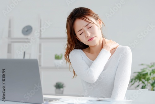 デスクワークで肩こりに悩む若い女性。健康_ストレス_疲労イメージ