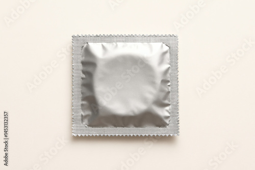 Obraz na płótnie Single condom in silver packaging on clean white background for safe sex concept w salonie
