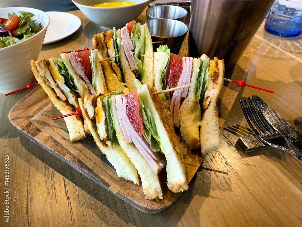 Lunch meal consisting of sandwich, soup and salad on table