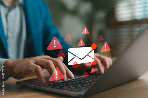 Businessman typing on laptop with warning email icons, representing email threat, phishing attack, malware, data breach, cybersecurity alert, scam message, spam risk, and online fraud protection. photo