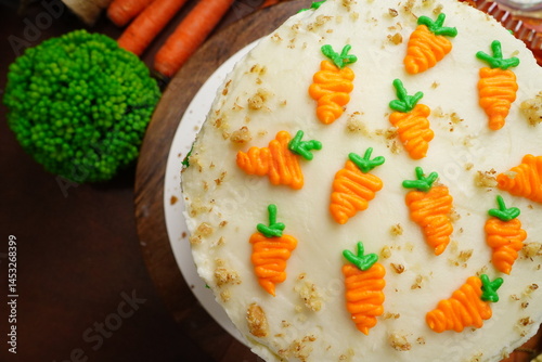 Carrot Cake with cream cheese icing made from scratch with freshly grated carrots.  Decorating a cake for a celebration or birthday party.  