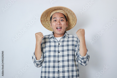 Young Indonesian farmer clench both his hand showing happiness photo