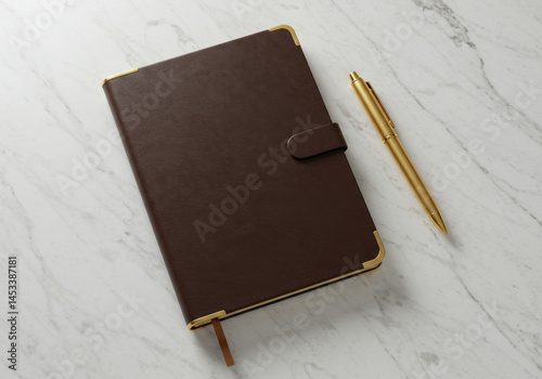 Brown leather journal with pen atop.