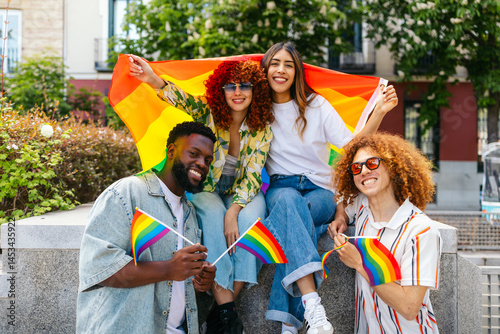 Group of diverse friends celebrating lgbt pride month with rainbow flags