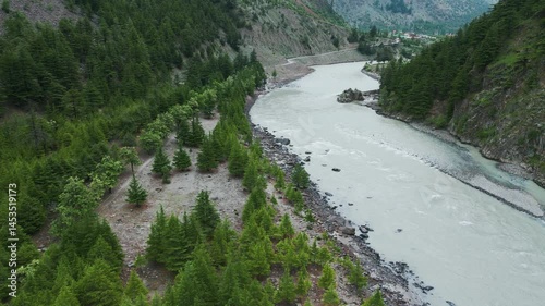  4K Bird's eye view of Chenab river flowing during the summer season as seen near Mini Manali in Lahaul, Himachal Pradesh, India. Summer travel background. Nature landscape.