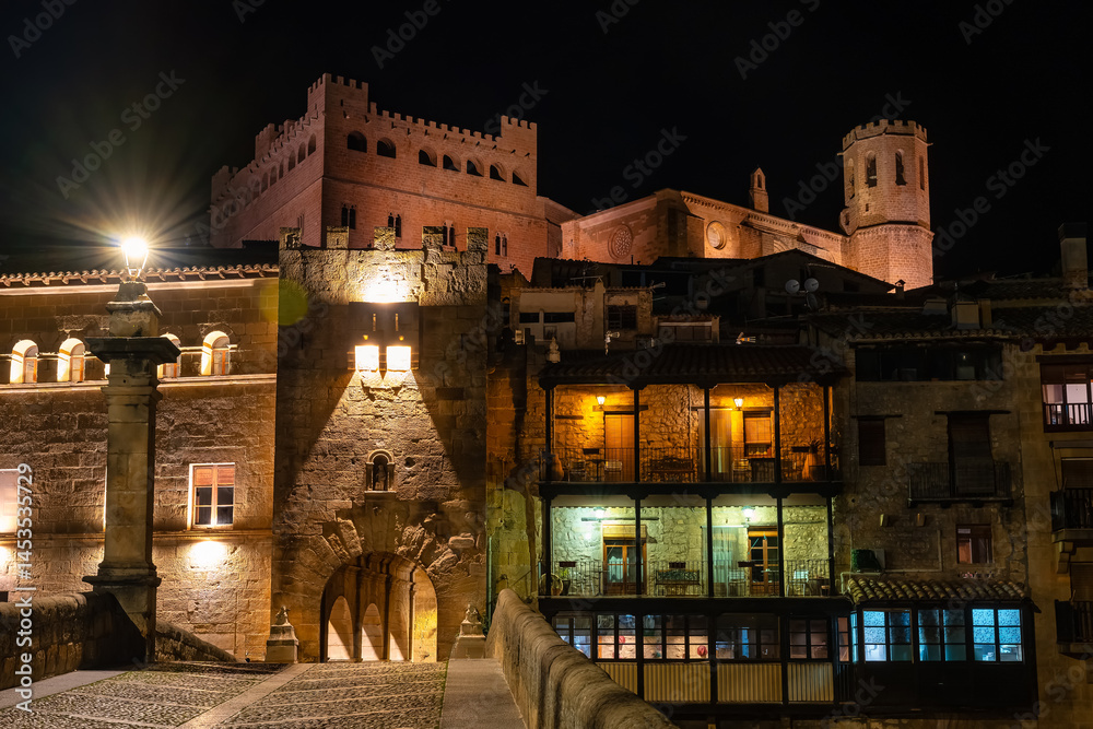 Roman bridge and monumental buildings in the tourist town of Valderrobles at night.