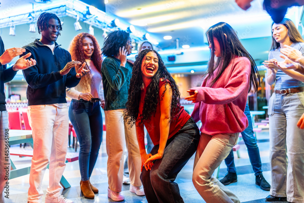 Happy multiethnic friends dancing and enjoying bowling alley weekend