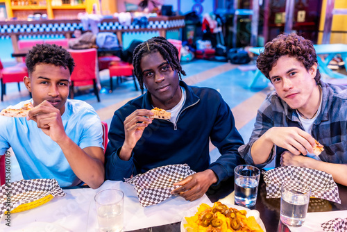 Obraz na płótnie Multiethnic friends enjoying pizza and nachos at bowling alley restaurant w salonie
